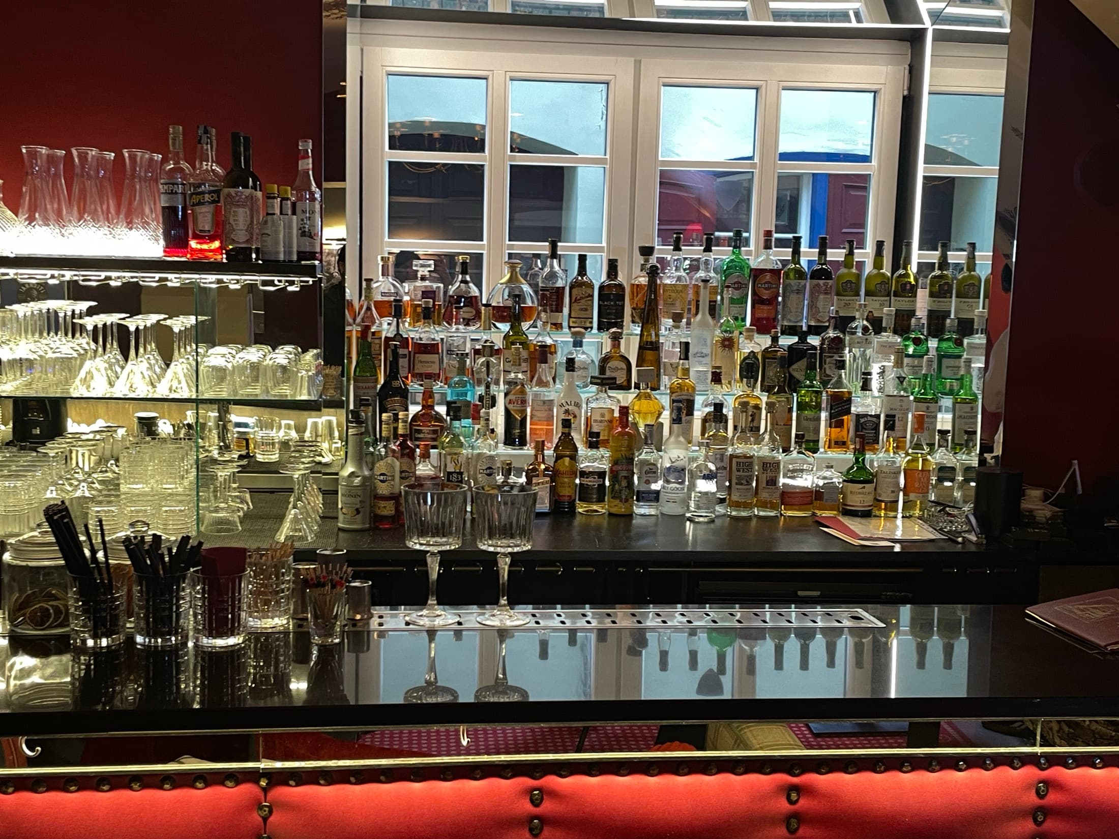 Bottles and glassware along a mirrored back bar